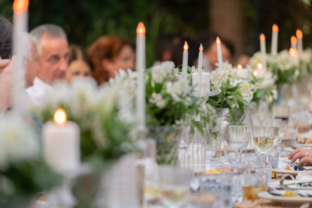 Group of people having dinner at wedding reception table at back yard.