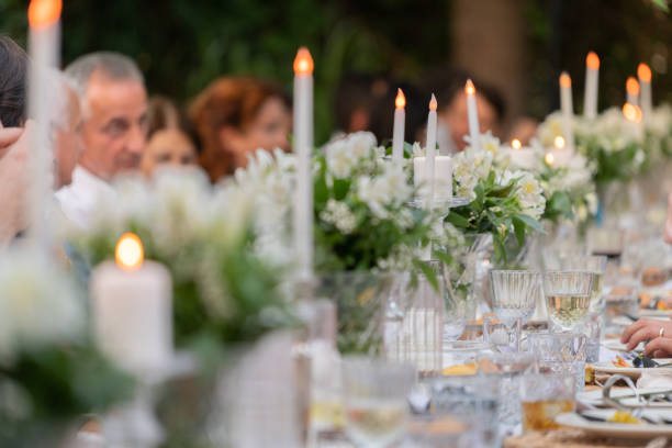 um grupo de pessoas jantando na mesa de recepção do casamento no quintal. - hotel hotel reception flower flower arrangement - fotografias e filmes do acervo