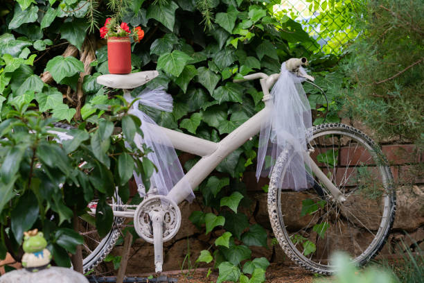altes fahrrad als ein blumenständer für dekorative zwecke umgebaut - bicycle ornamental garden flower formal garden stock-fotos und bilder