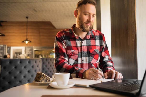 istock Businessman having coffee and doing his work in cafe. male employee pondering considering idea looking at computer screen making decision 1400799620