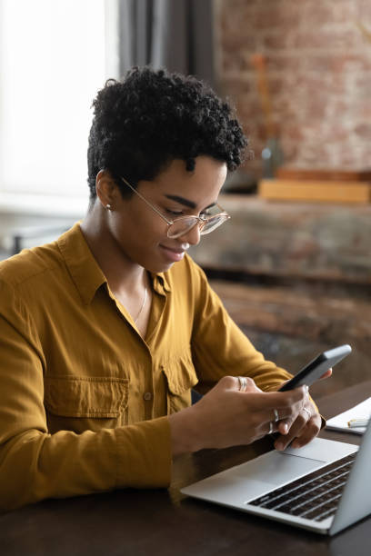 istock Pensive positive young African gadget addict user woman using cellphone 1400800109
