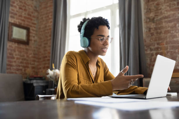 istock Busy focused stylish Black worker in headphones talking to client 1400801414