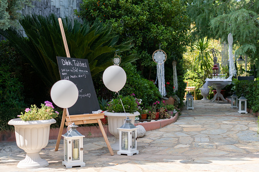 Welcome board at wedding reception in home yard entrance.