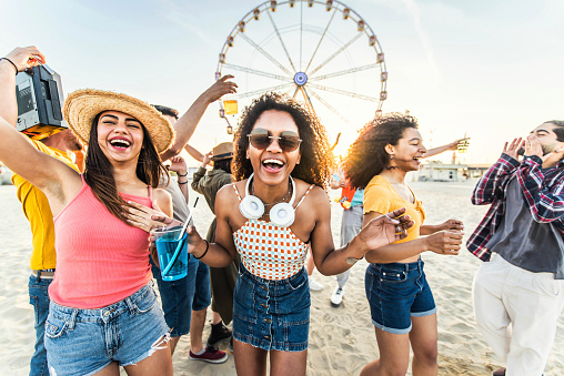 Multiracial group of friends having fun dancing on the beach - Happy people enjoying music festival on weekend vacation - Joyful tourists celebrating summer holiday together - Youth lifestyle concept