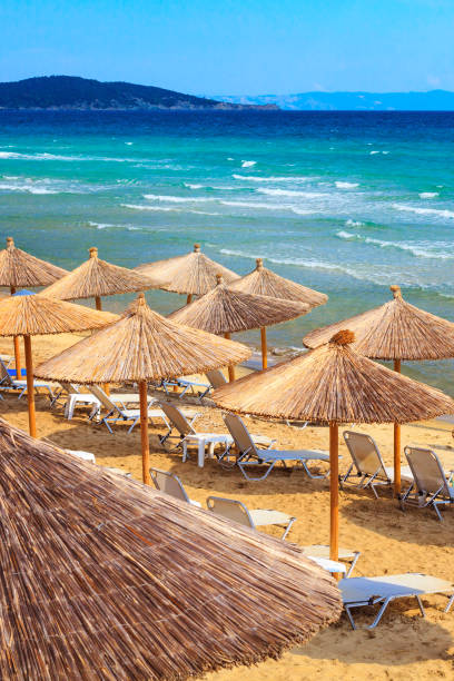 sarti, grecia sfondo spiaggia con onde del mare e ombrelloni - vacations halkidiki beach sand foto e immagini stock