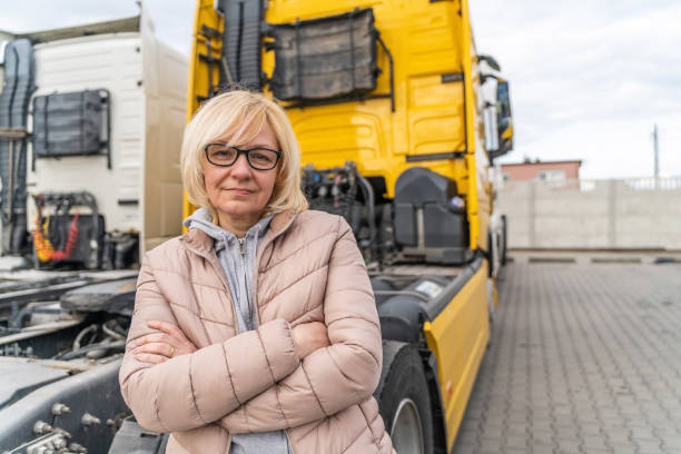 Caucasian mid age woman driving truck. trucker female worker, transport industry occupation stock photo