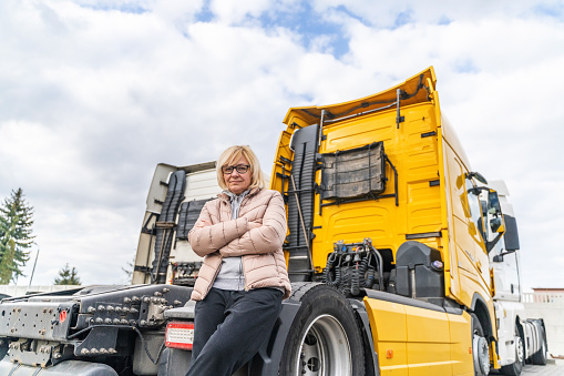 Caucasian mid age woman driving truck. trucker female worker, transport industry occupation . High quality photo