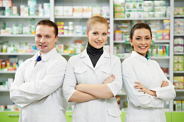 Pharmacy chemist team women and man in drugstore stock photo