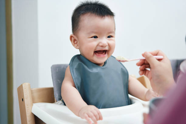 istock Asian baby boy happy while being fed by spoon 1400805320