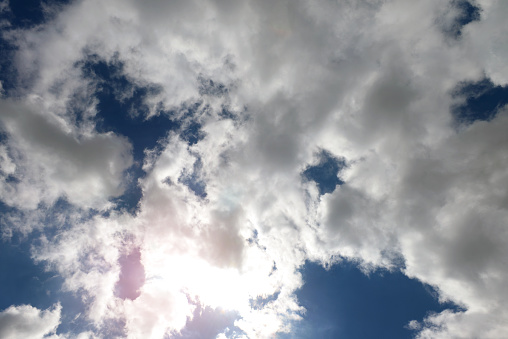 cumulus clouds against the sky and the sun