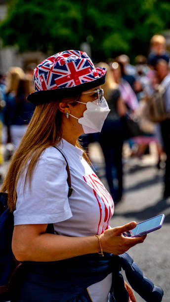 mädchen mit maske auf dem weg zum buckingham palace - elizabeth ii queen nobility british flag stock-fotos und bilder