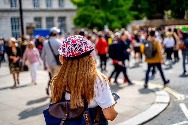 バッキンガム宮殿に向かって歩くマスクをした少女 - elizabeth ii queen nobility british flag ストックフォトと画像