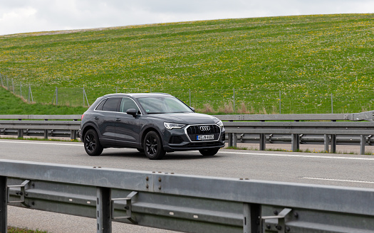 Kempten, Allgäu, Schwaben, Bavaria, Germany, may 1st 2022, a German Audi Q3 SUV from the Kempten im Allgäu district approaching on the German A7 Autobahn at Kempten - with a length of 963 km between the borders of Denmark in the north and Austria in the south, the Autobahn 7 is the longest Autobahn in Germany - the majority of the German Autobahn does not have a mandatory but only an advisory speed limit