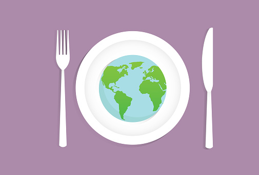 A globe on a dish with fork and a knife