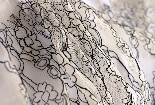 White and black lace textile fabric, abstract background, close-up