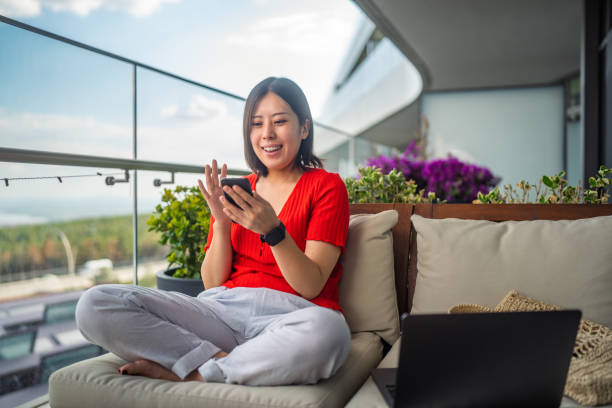 istock Young woman using smart phone for video call at balcony 1400814928