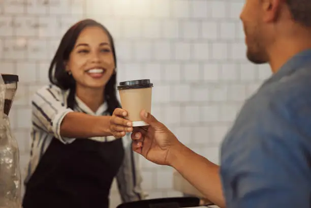 Barista giving a customer their cup of coffee. Customer collecting their coffeeshop order. Businesswoman giving a customer their order. Entrepreneur giving a customer a cup of tea