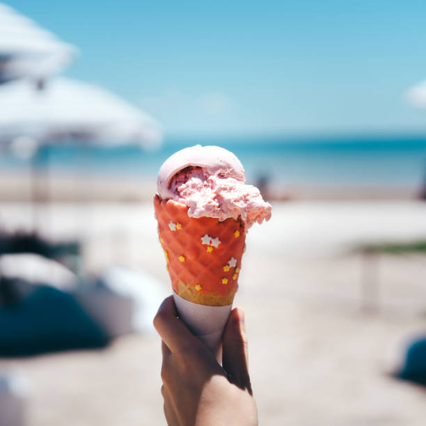 istock Hand grab ice cream cone at beach outdoor cafe on day. 1400818205