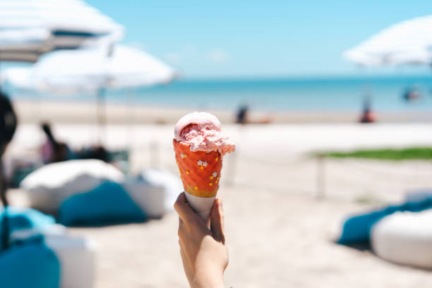 istock Hand grab ice cream cone at beach outdoor cafe on day. 1400818465