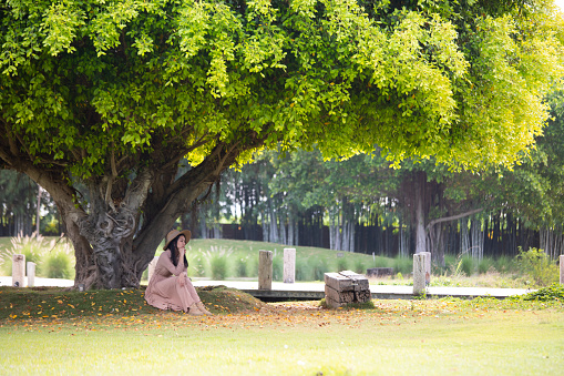 woman sitting under a tree