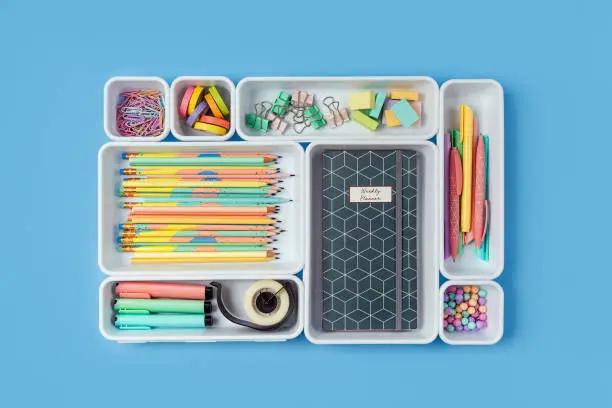 Photo of Stylish colored school stationery is arranged in organizers. Creative Drawer Organizing. Storage office supplies. Concept back to school.