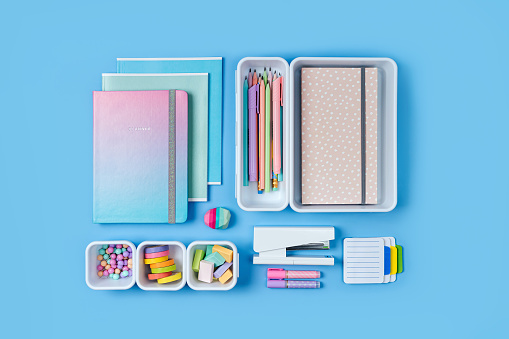 Notebooks and stylish school stationery is arranged in organizers. Creative Drawer Organizing. Storage office supplies. Concept back to school.