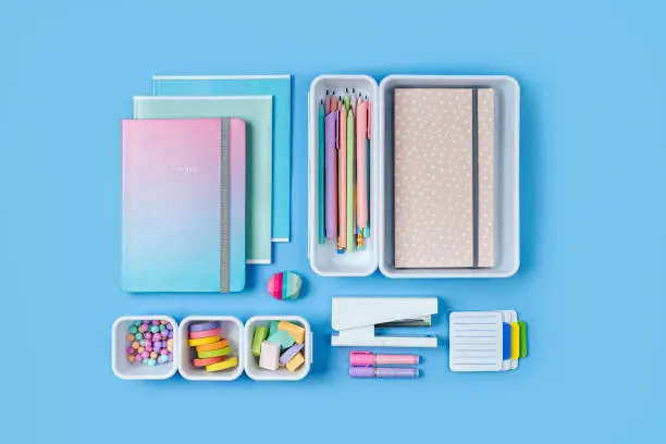 Photo of Notebooks and stylish school stationery is arranged in organizers. Creative Drawer Organizing. Storage office supplies. Concept back to school.