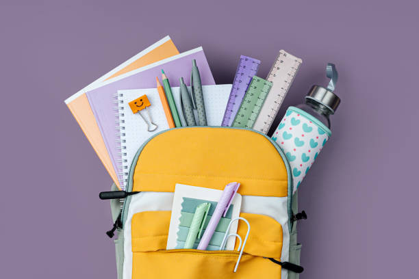 istock Opened School backpack with stationery  on purple background. Concept back to school. School supplies. 1400820327