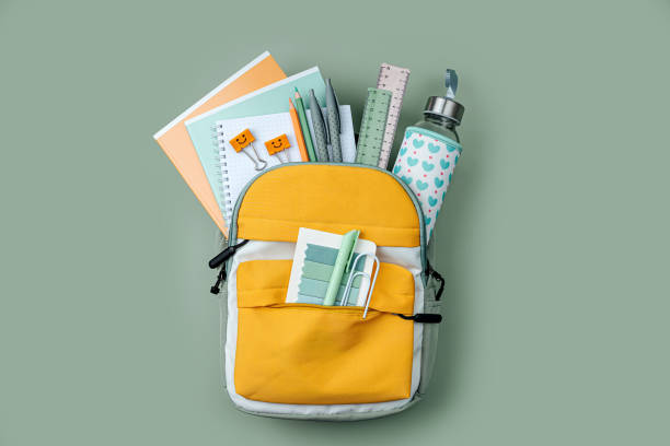 opened school backpack with stationery  on green background. concept back to school. school supplies. - mochila imagens e fotografias de stock