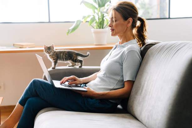 istock Ginger mature woman typing on laptop while sitting on couch 1400823097