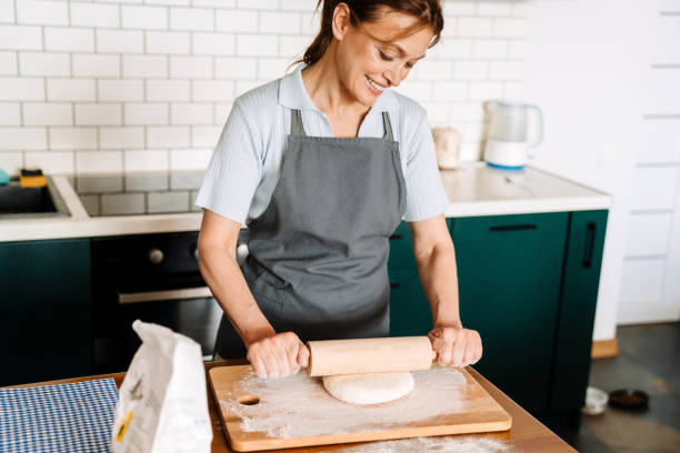 istock Ginger mature woman making dough with rolling pin in kitchen 1400823490