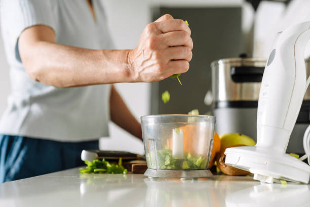 istock White mature woman cooking with blender in kitchen 1400823753