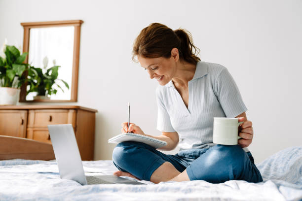 istock Ginger mature woman writing down notes while working with laptop at home 1400824162