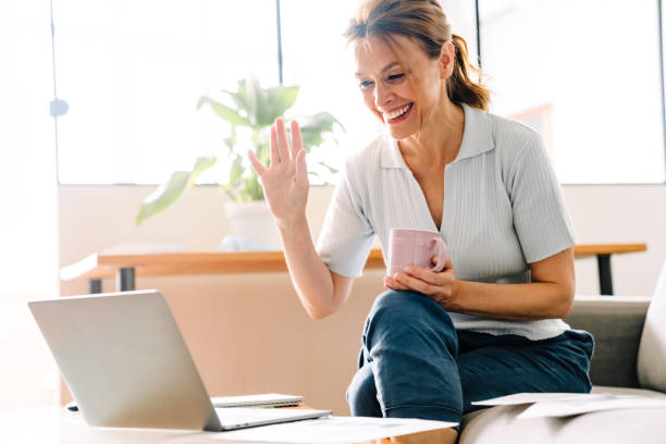 istock Ginger mature woman drinking coffee while working with laptop at home 1400824368