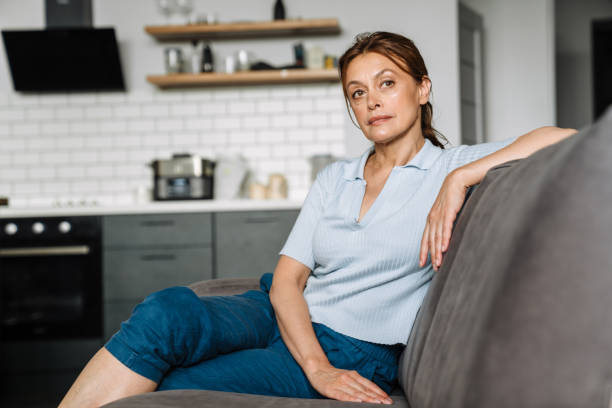 istock Ginger mature woman looking ahead while sitting on couch 1400825206
