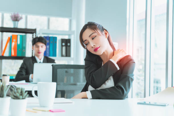 istock Female office worker is suffering from office syndrome, using her hand to rub on her should to ease the pain. 1400825210