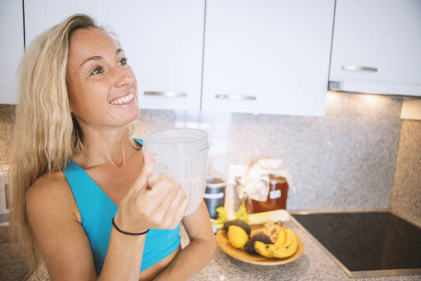 istock Woman drinking a smoothie at home before her workout 1400826161