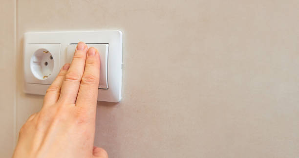 istock A woman's hand presses a light switch in an apartment close-up, copy paste 1400826958