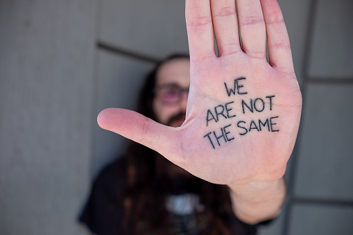 We are not the same. Tatoo on man`s hand.