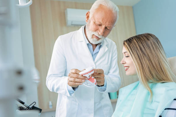 istock Dentist showing teeth model to a patient 1400828867