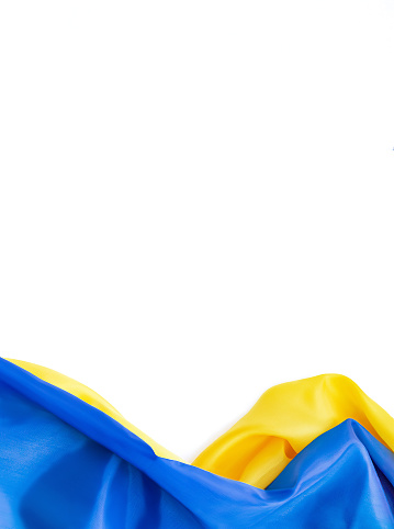 National flag of Ukraine. Fabric curved in yellow-blue colors ribbons on white background. National symbol of country. Europe. Copy space. Empty space for your message.