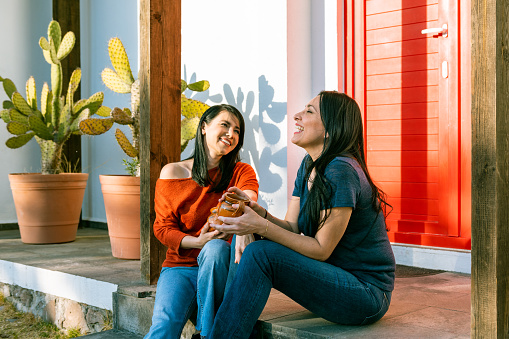 Lesbian couple sitting on vacation rental porch