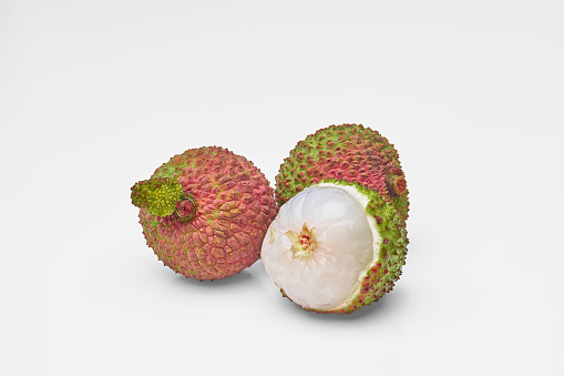 Peeled lychees and peeled lychees, isolated on a white background. Close-up