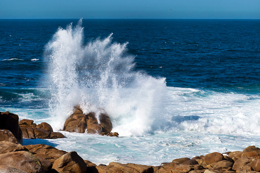 Breaking wave and rocky coastline, seascape  seen from Punta da Barca, Muxía, Costa da Morte, A Coruña province,  Galicia, Spain. End of Camino de Santiago, camiño dos faros.