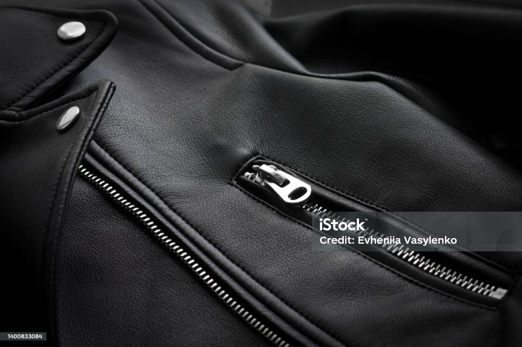 Black leather jacket. The texture of the skin in clothing. Clothing accessories, rivets, buttons, zipper. Sewing leather clothes Female leather jacket Leather Jacket Stock Photo