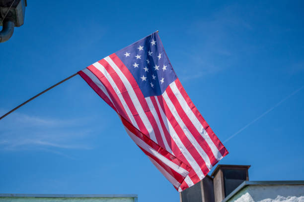 istock flag flies against a blue white sky 1400835838