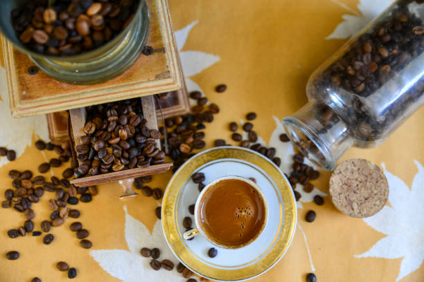 Turkish coffee and old manual coffee grinder with roasted coffee beans on the table