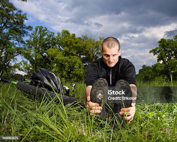 Ciclista Di Mountain Bike Stretching Nella Foresta - Fotografie stock e altre immagini di Adulto - Adulto, Ambientazione esterna, Ambiente