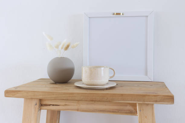 istock Horizontal white frame mockup on a vintage wooden bench, table. Modern ceramic vase with dry Lagurus ovatus grass. White wall background. Scandinavian interior. Selective focus. 1400838289