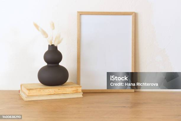 Horizontal White Frame Mockup On A Vintage Wooden Bench Table Modern Ceramic Vase With Dry Lagurus Ovatus Grass And Books White Wall Background Scandinavian Interior Selective Focus Stock Photo - Download Image Now